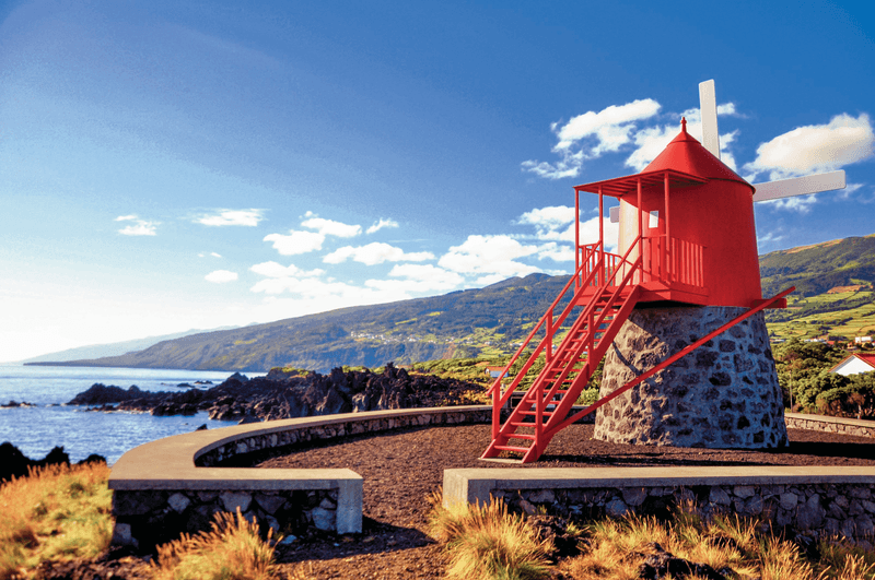 Traditional and symbolic red windmill at the coast of Pico island, Azores, Portugal