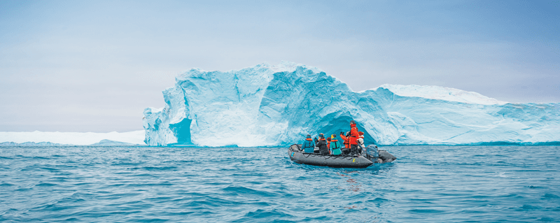 Guests explore the towering Icebergs Ilulissat Icefjord, Greenland.