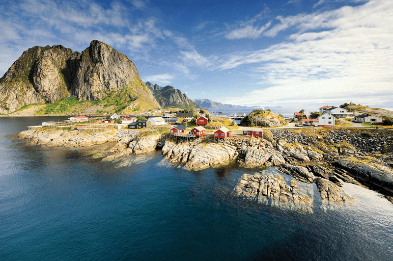 Scenic fjord on Lofoten islands, with typical red fishing hut and towering mountain peaks, Sakrisoy, Norway