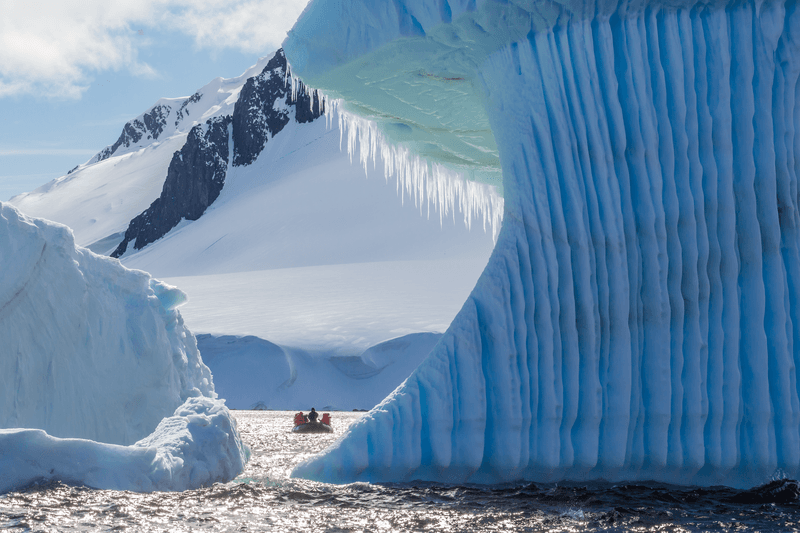 Guests from the Lindblad Expedition ship National Geographic Explorer enjoy Dorian Bay, Antarctica by Zodiac.