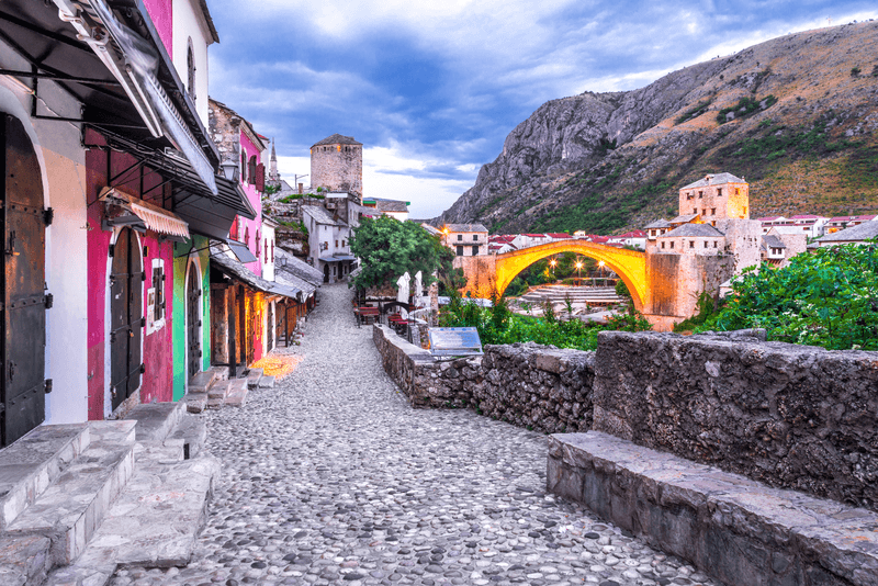 Mostar, Old Town, Bosnia and Herzegovina, Europe. Skyline of Mostar with the Stari Most Bridge, houses and minarets, at sunrise.