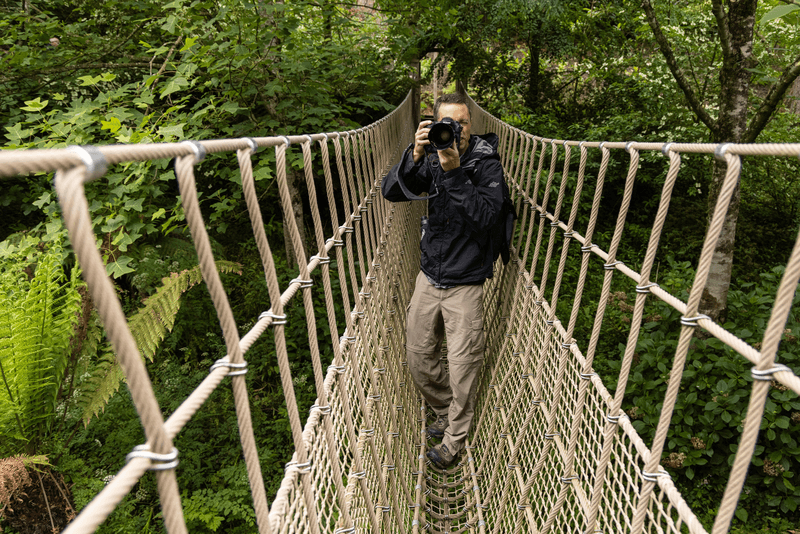 National Geographic photographer, Jeff Mauritzen, taking photos on the rope bridge in the Lost Gardens of Heligan. Located near Mevagissey in Cornwall, England and are considered to be amongst the most popular in the UK.