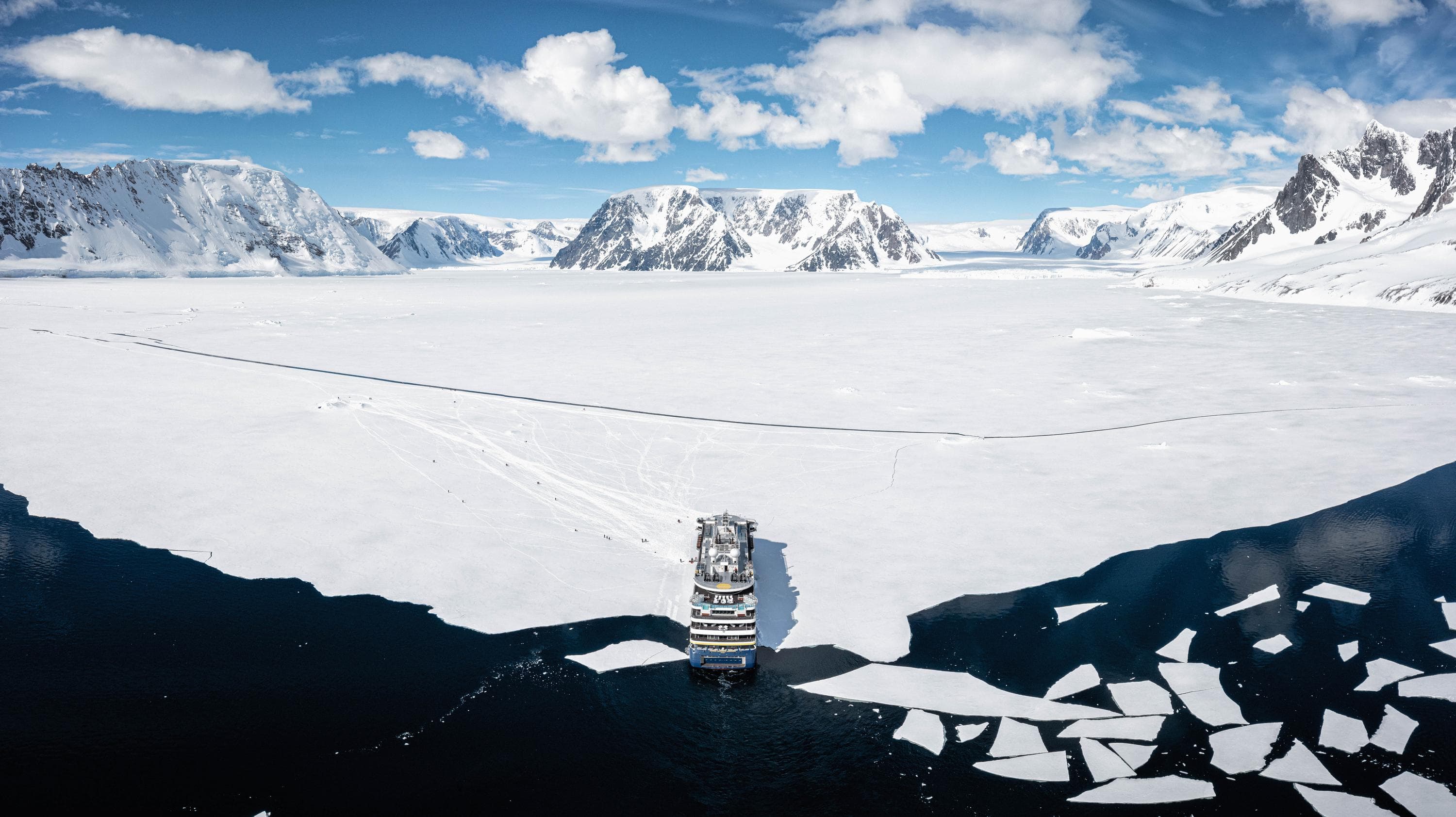 Aerial view of the Lindblad Expeditions ship,  National Geographic Endurance, in pack ice with guests out ice hiking, Antarctica