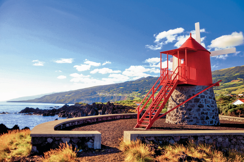 Traditional and symbolic red windmill at the coast of Pico island, Azores, Portugal