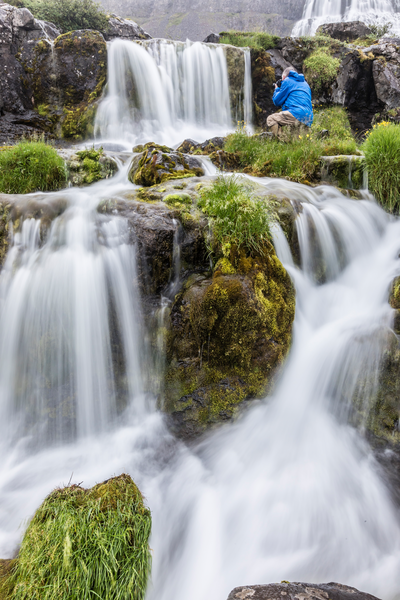 A guest photographing the Dynjandi waterfall, also known as Fjallfoss, in Westfjords of Iceland