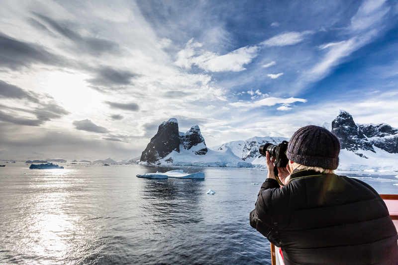 Guest from the ship National Geographic Explorer enjoy photographing Lemaire Channel, in Antarctica, Southern Ocean