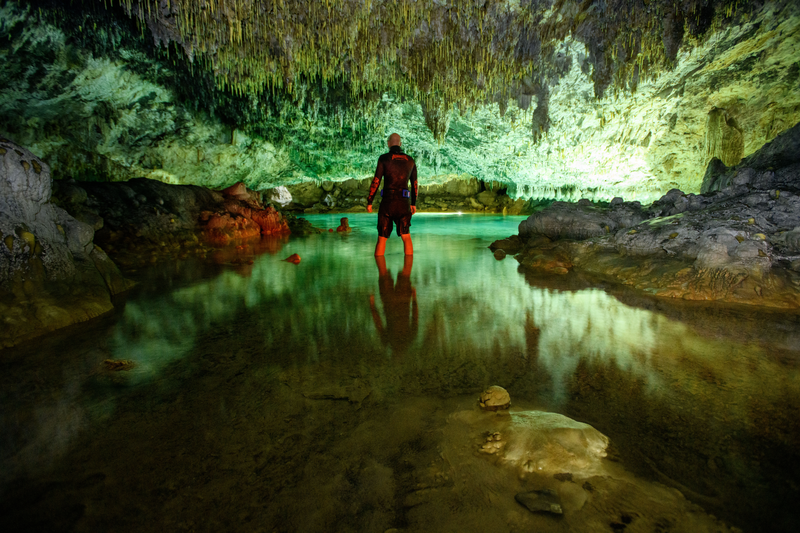 Expedition leader Jimmy White explores a cave on the island of Makatea in the Tuamotu Archipelago of French Polynesia. underwater dive lights.