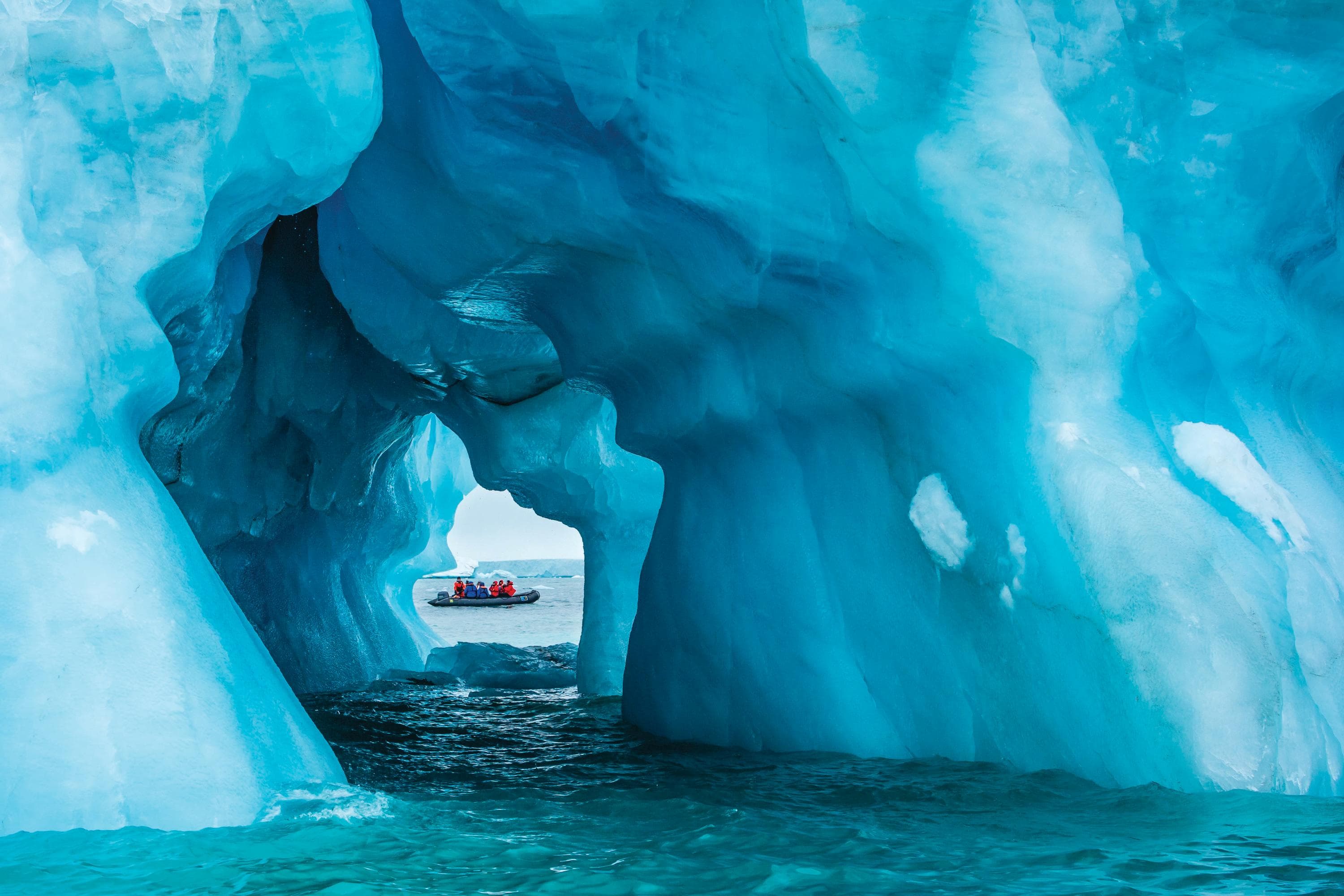 Guests explore a sea ice cave by zodiac in Queens Bay, Philpots Island, Lancanster Sound, Canada, Northwest Passage