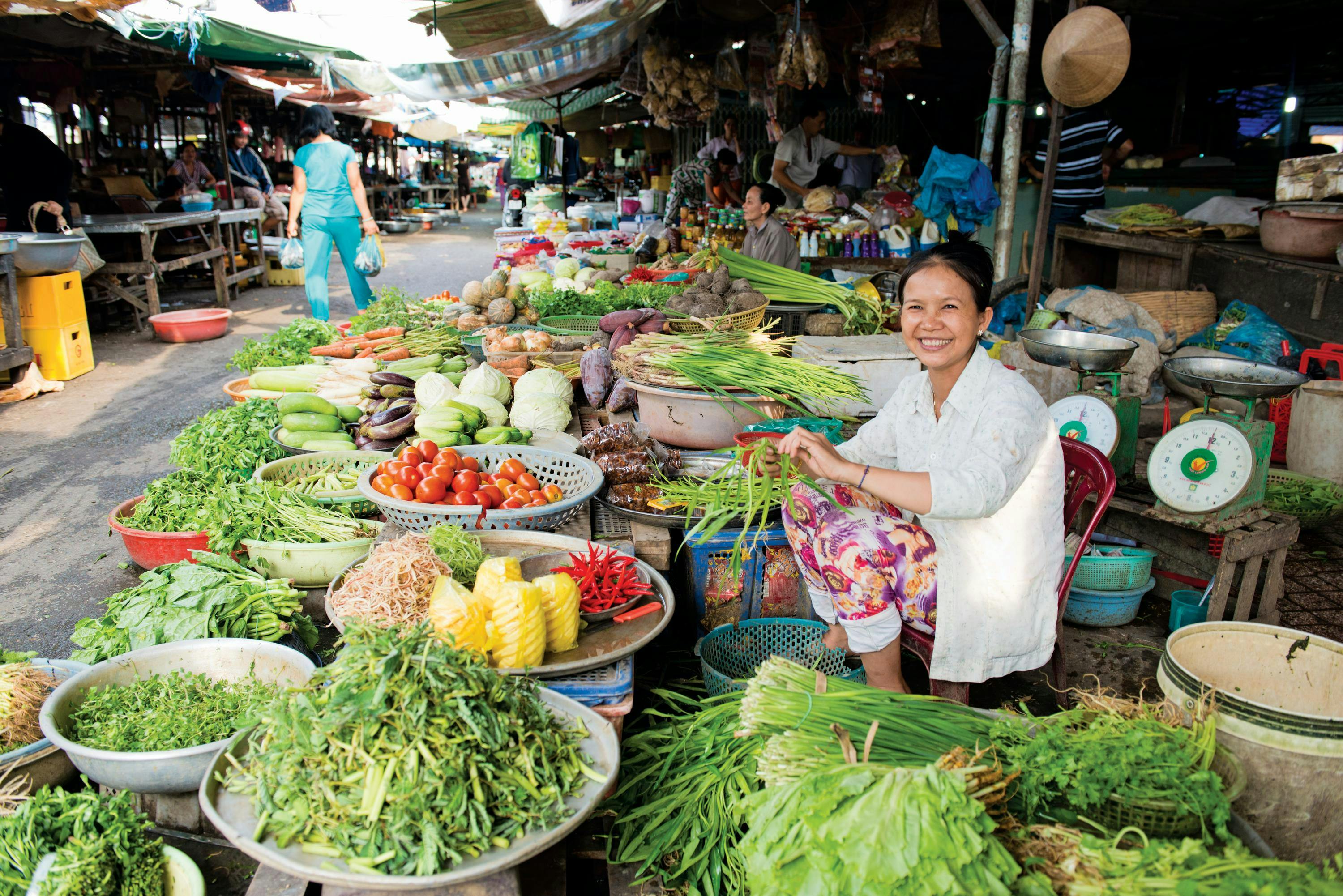 A vendor prepares produce at a local market in Cai Be, Vietnam