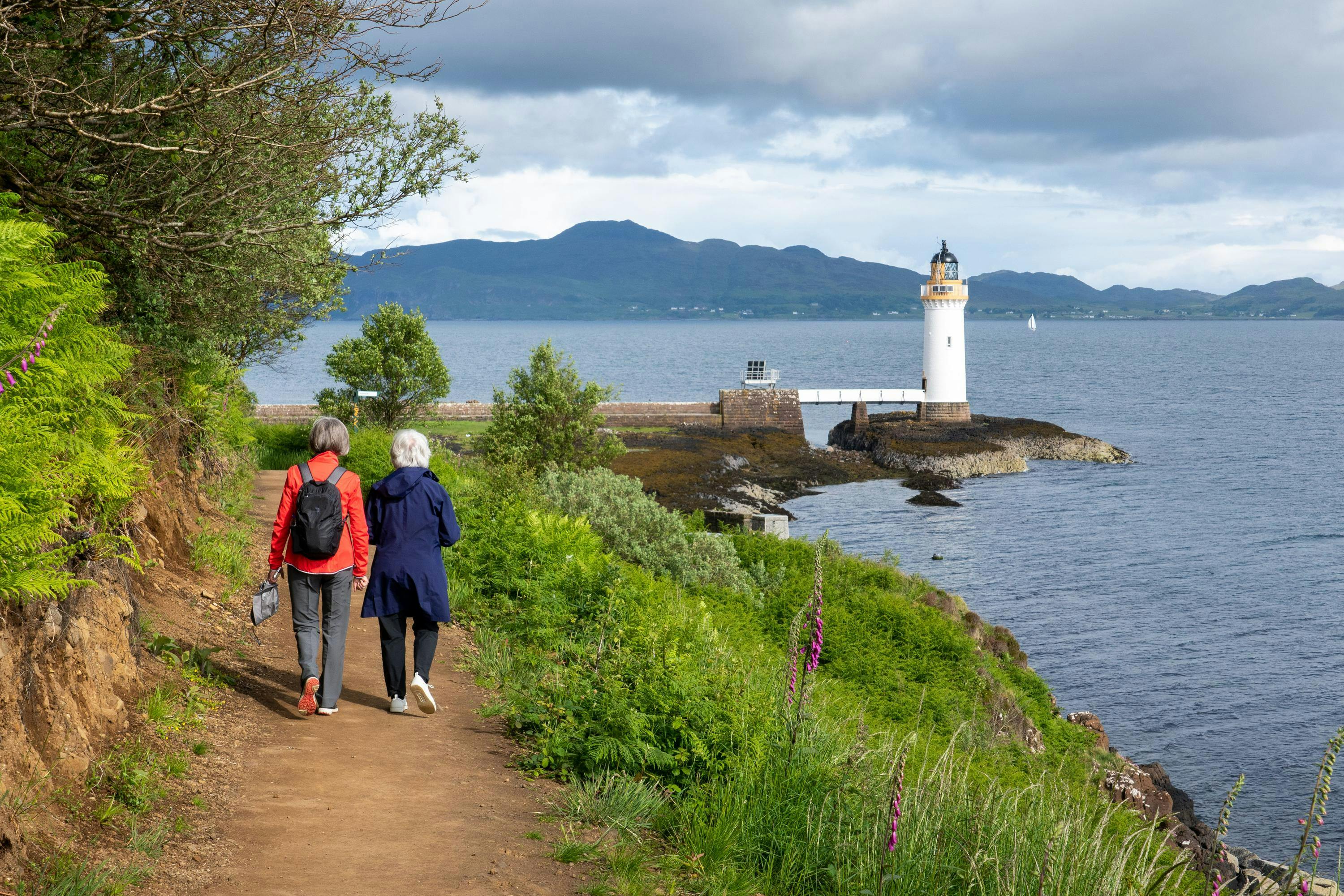 Two guests walking exploring Scotland's coast in Tobermory, Burgh in Mull, Isle of Mull, Scotland. 