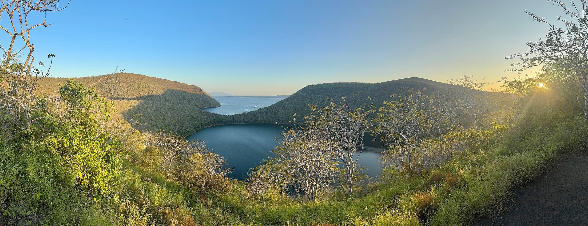 a lake surrounded by grassy hills