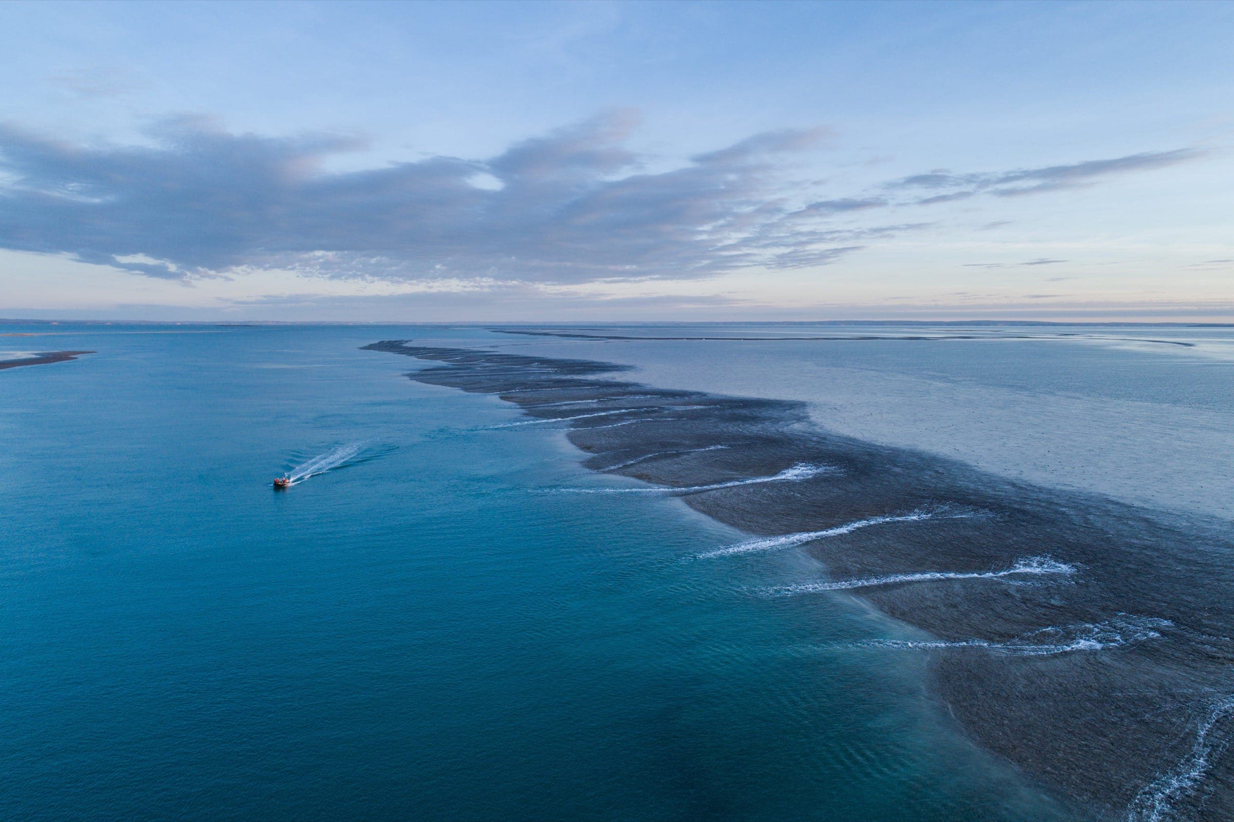 A long long streak of ocean, darkened by the reef underneath