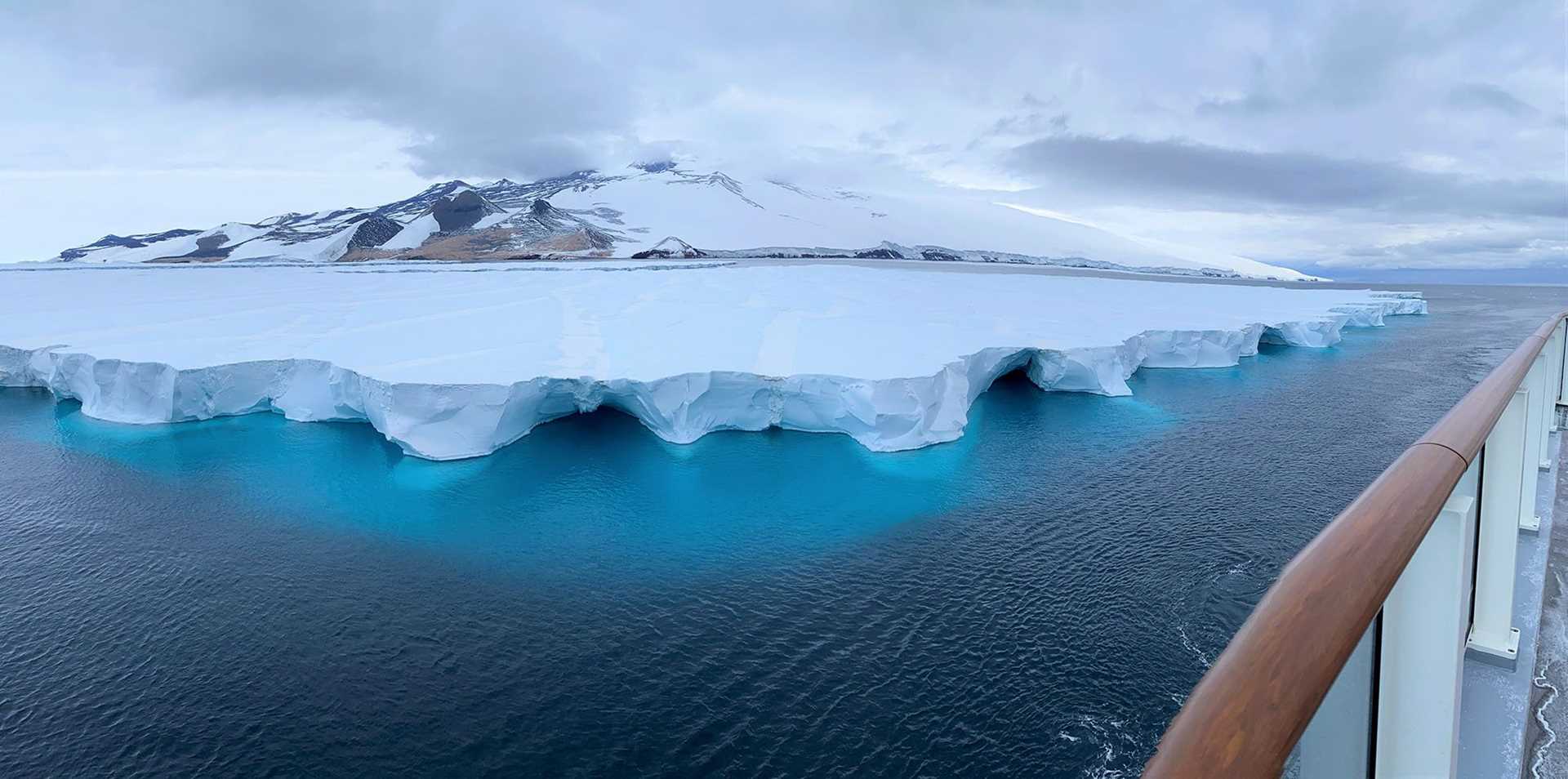 large ice shelf on top of blue water