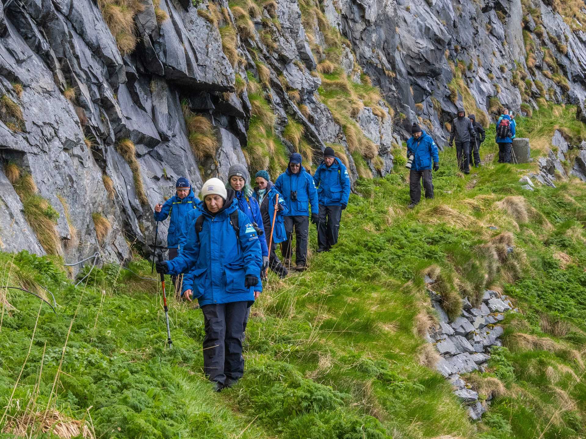 Guests hiking in blue parkas in Vaeroya, Norway