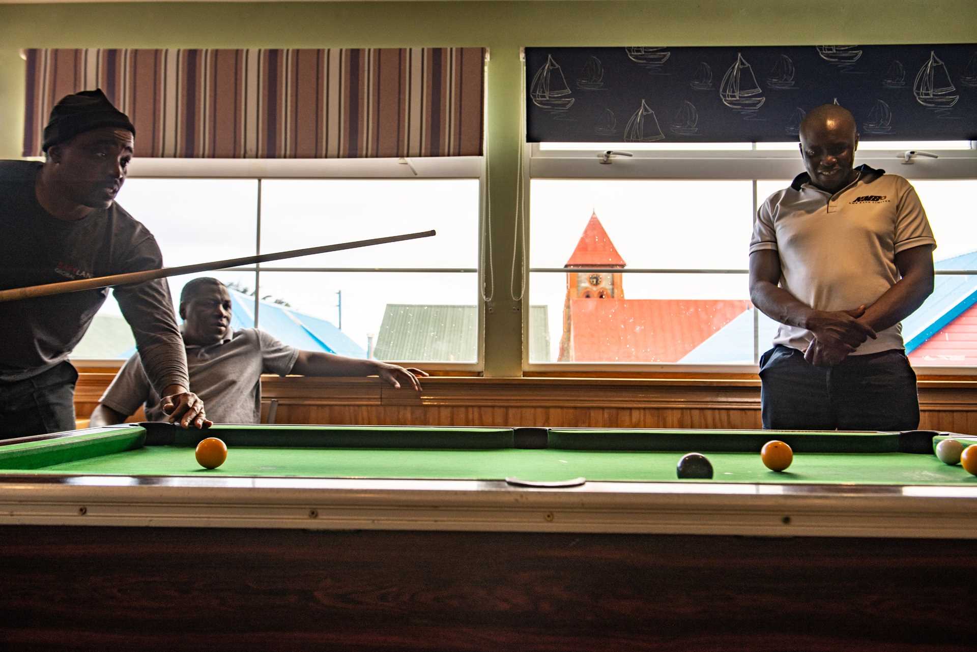 Zimbabwean de-mining workers play billiards at Miller's Guest House in the Falkland Islands