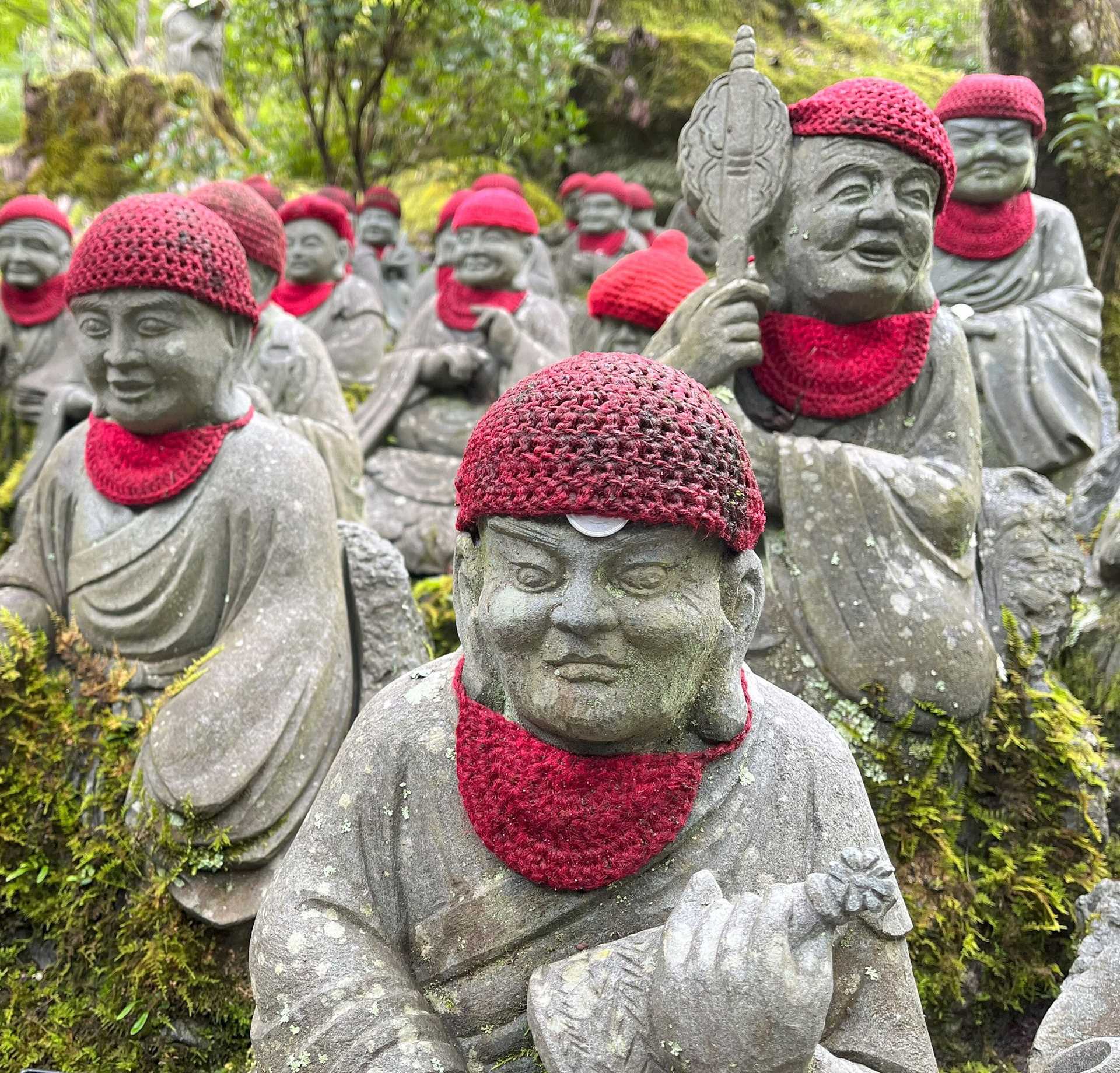 small, round gray statues in pink hats