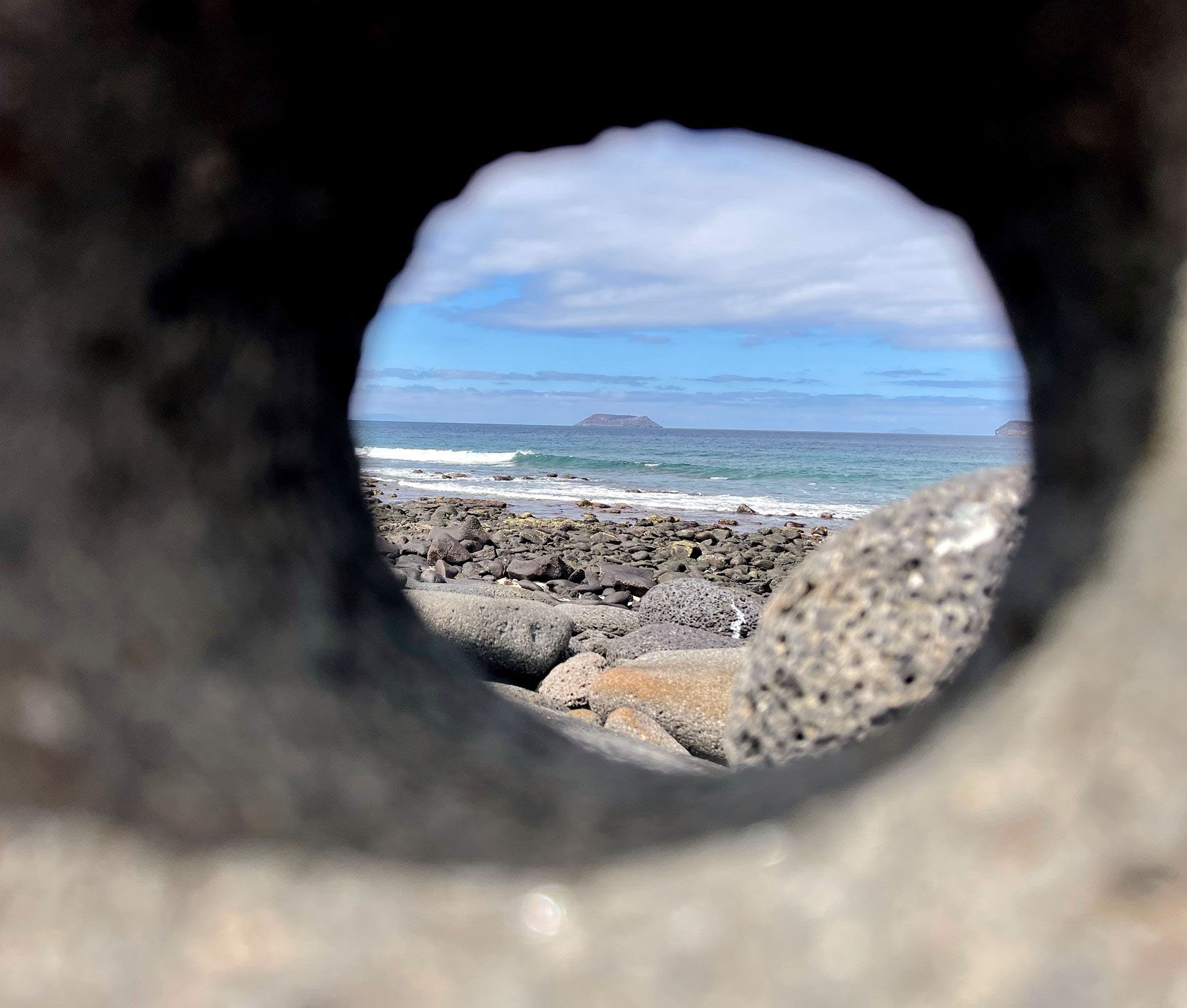 shot of island through a hole in a rock